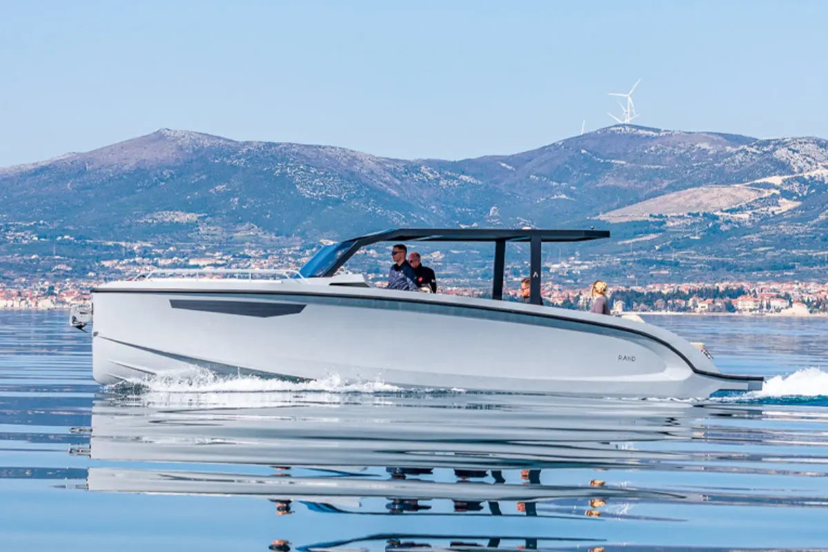 Modern Rand Archipelago 32 Electric Boat on a calm body of water with mountains in the background