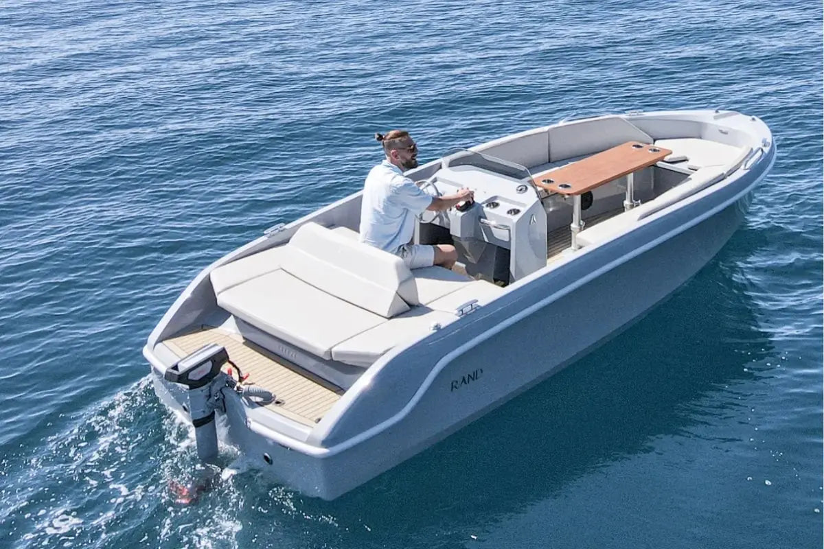 Person on a white Rand Breeze 20 Electric Boat in the water