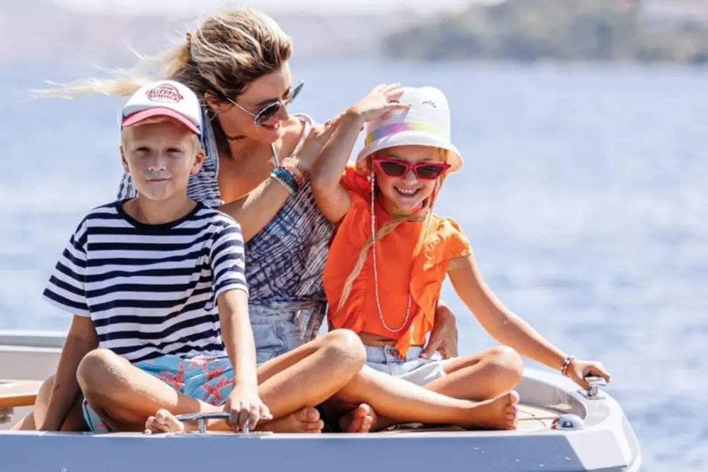 Woman and two children on Rand Mana 24 Electric Boat with a scenic background