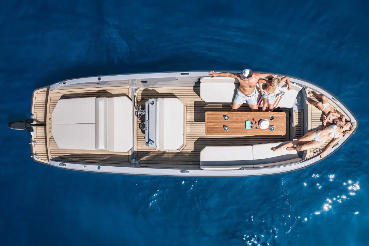 Aerial view of Rand Mana 24 Electric Boat with people on a clear blue water surface