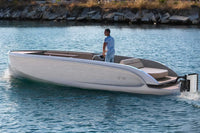 Man standing on a modern Rand Mana 24 Electric Boat on a body of water.