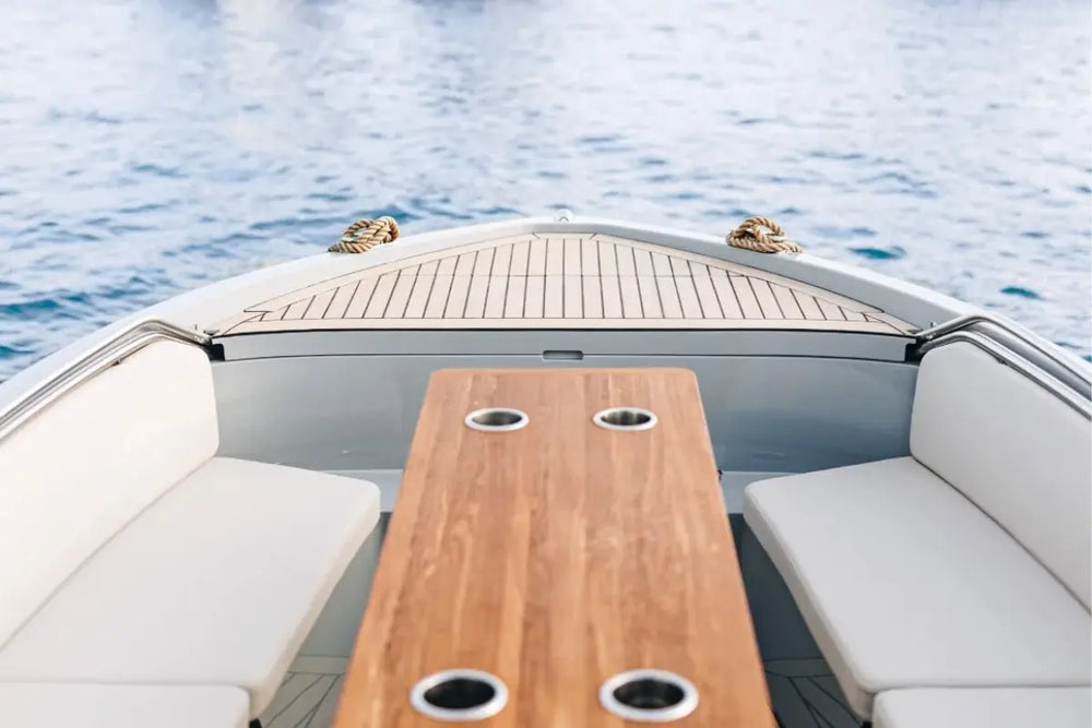 Rand Mana 24 Electric Boat bow with a wooden table and white seats on a body of water