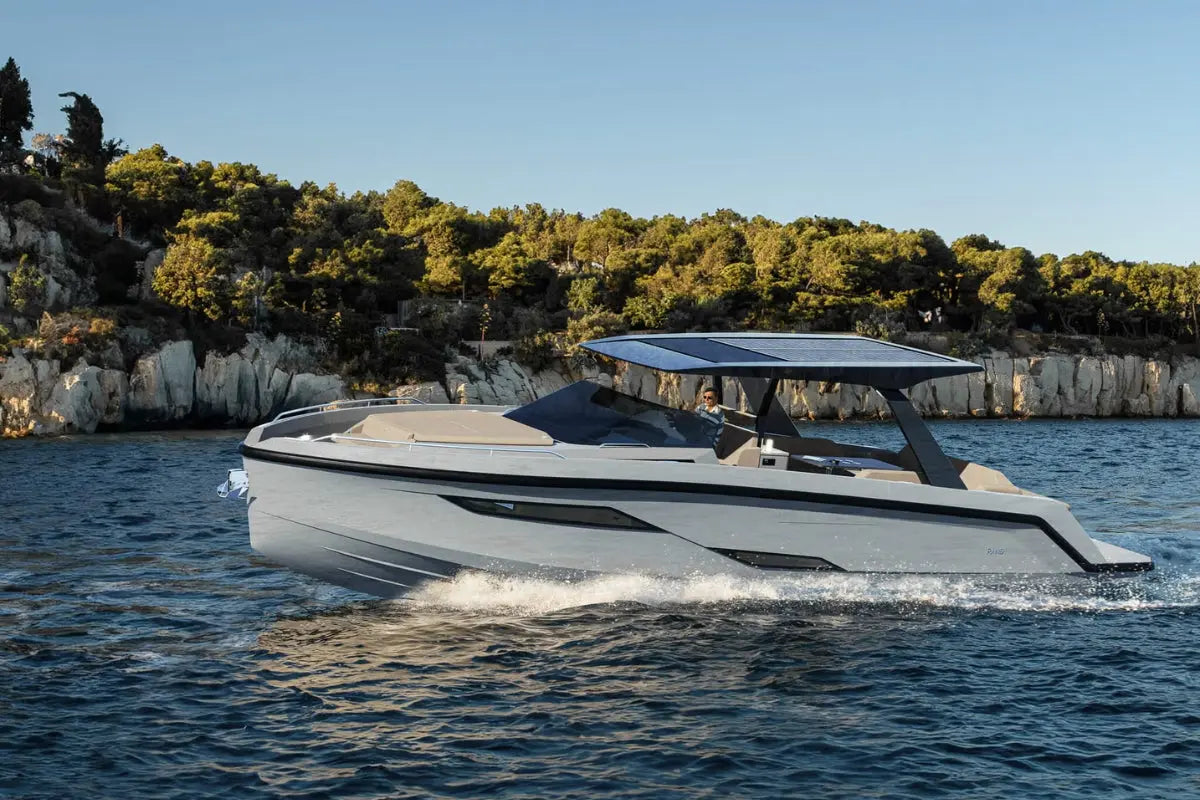 Modern Rand Realm 44 Electric Boat on water with a scenic background of trees and cliffs.