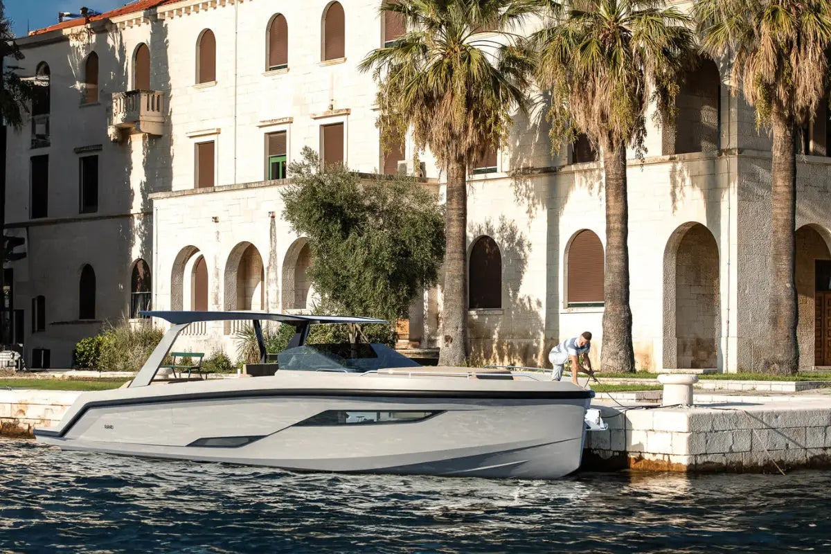 White Rand Realm 44 Electric Boat on water with classical architecture and palm trees in the background