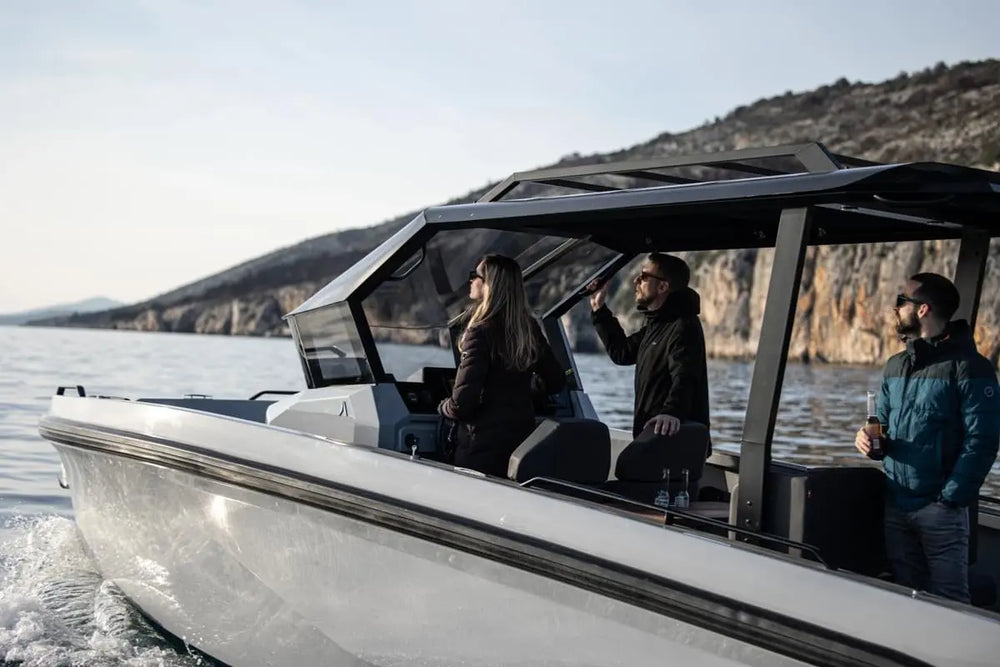 People on Rand Roamer 29 Electric Boat in the water with a scenic background