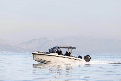 Rand Roamer 29 Electric Boat on a body of water with mountains in the background