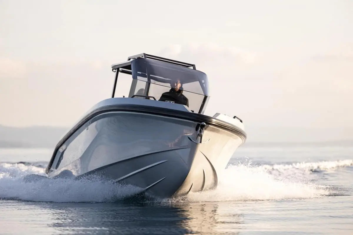 Rand Roamer 29 Electric Boat speeding on water with a person inside, set against a light background