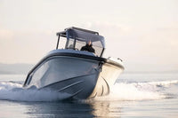 Rand Roamer 29 Electric Boat speeding on water with a person inside, set against a light background