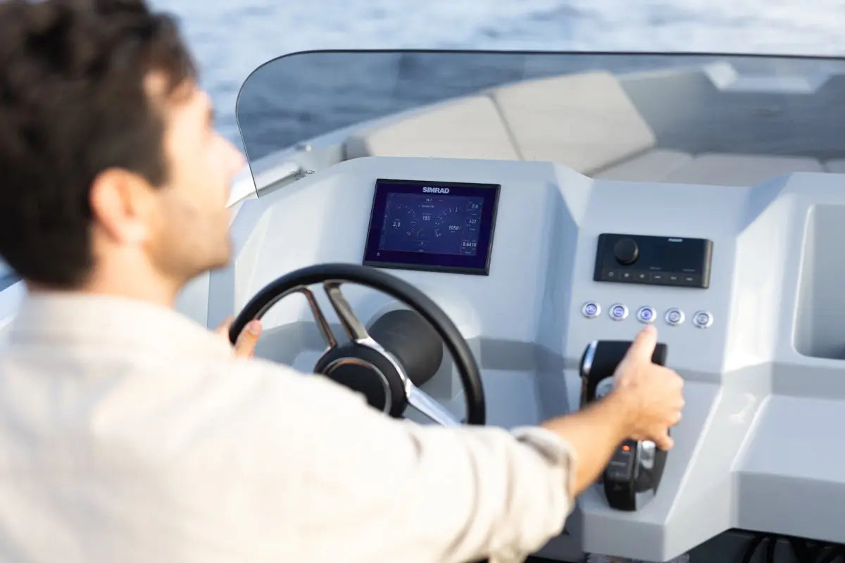 Person operating Rand Source 22 Electric Boat with a control panel and screen.