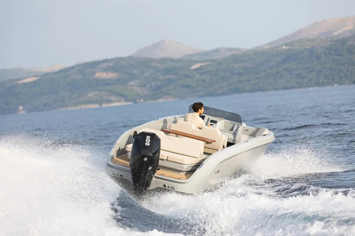 Person on Rand Source 22 Electric Boat with mountains in the background