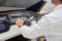 Person inside a luxury Rand Spirit 25 Electric Boat, holding the steering wheel.