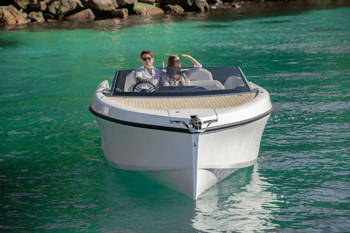 Rand Spirit 25 Electric Boat with two people on a turquoise body of water