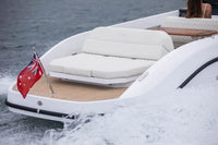 Rand Spirit 25 Electric Boat with cushioned seating area and a flag on a body of water