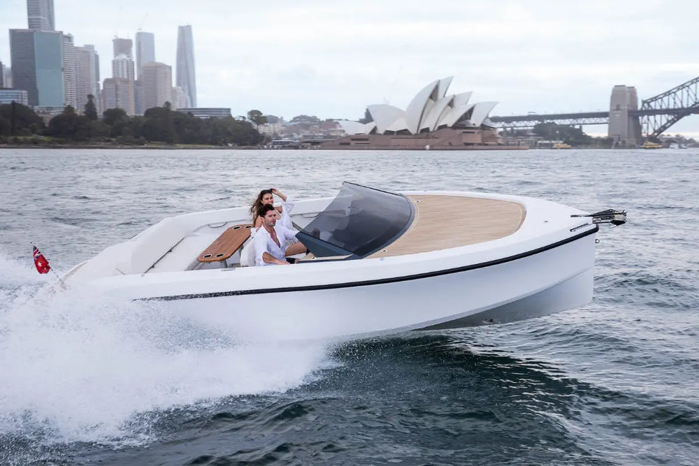 Rand Spirit 25 Electric Boat on water with a cityscape including the Sydney Opera House and bridge in the background.