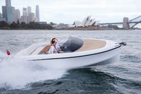 Rand Spirit 25 Electric Boat on water with a cityscape including the Sydney Opera House and bridge in the background.
