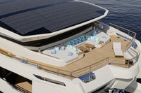 Modern Silent 120 Explorer Electric Boat with solar panels on the roof, deck area with seating, and ocean in the background.