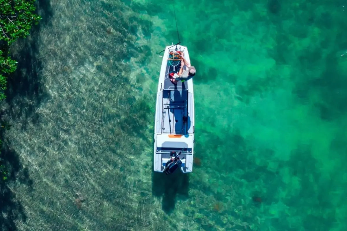 Veer V13 Electric Boat floating on clear green water with a person inside, surrounded by trees.