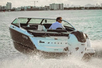 Man driving Vision H2e Bowrider Electric Boat on water with city skyline in the background