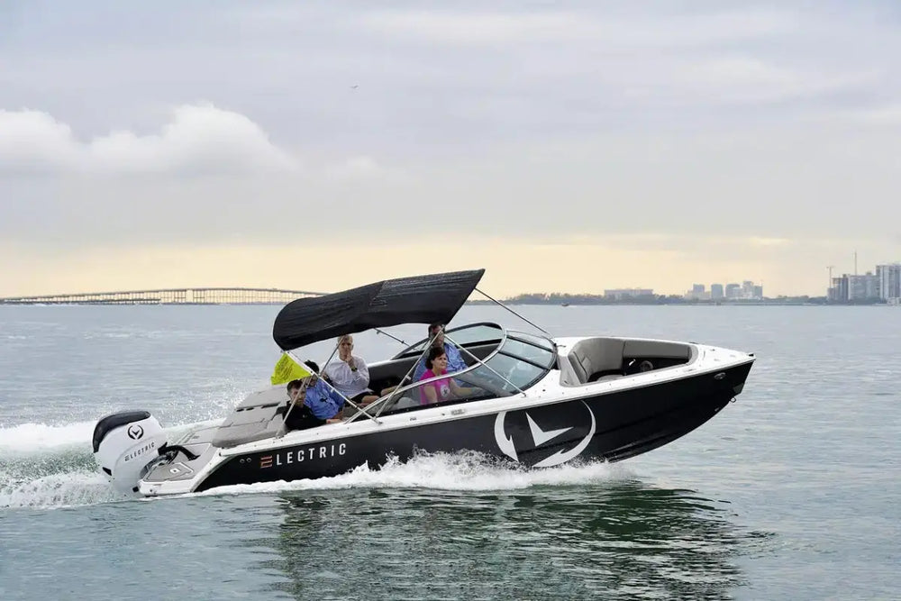 Vision H2e Bowrider Electric Boat on water with people onboard, city skyline in the background