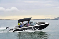 Vision H2e Bowrider Electric Boat on water with people onboard, city skyline in the background