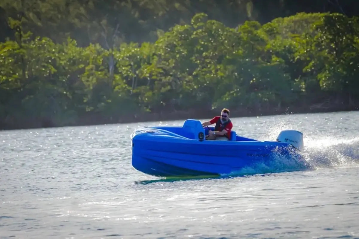 Person in Vision Phantom Electric Boat on a lake with trees in the background
