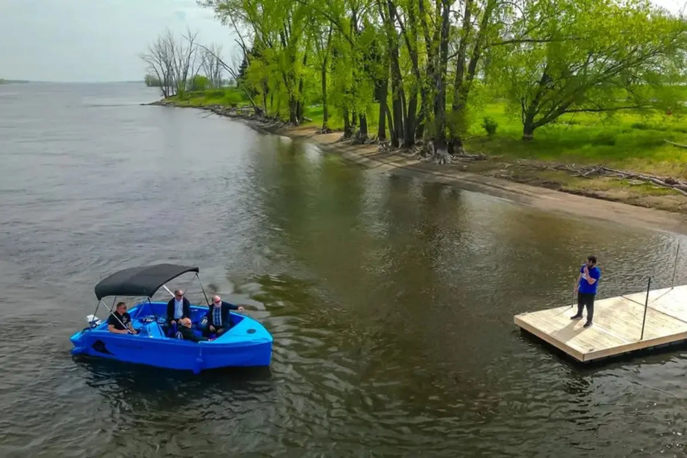 Vision Phantom Electric Boat on a lake with people on board, near a dock.