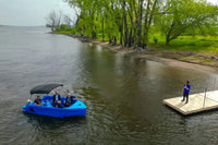 Vision Phantom Electric Boat on a lake with people on board, near a dock.