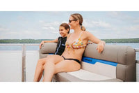 Two women sitting on Vision V17 Electric Boat on a lake with a scenic background.