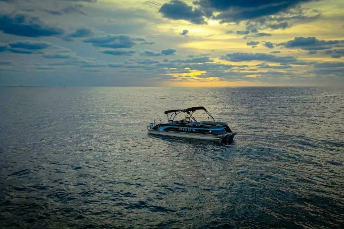 Vision V30 Electric Boat on the ocean with a sunset sky