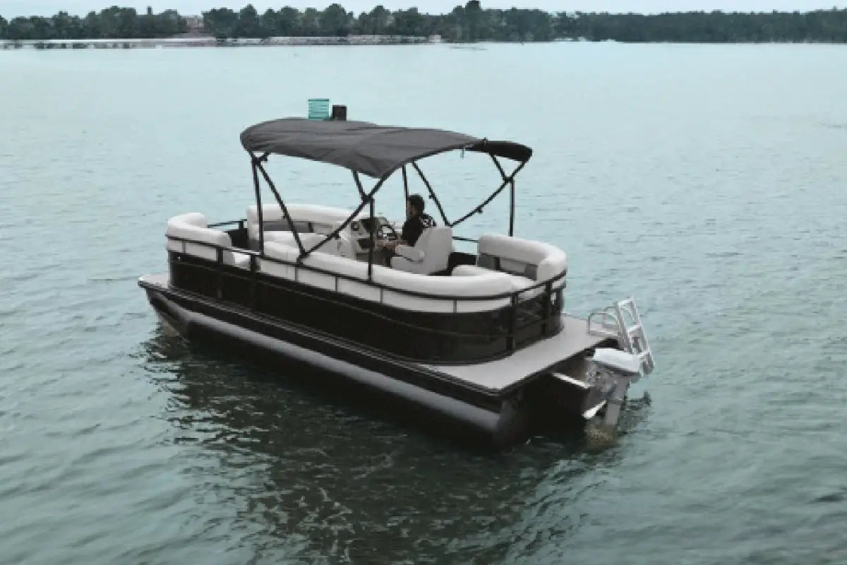 Vision WX Tritoon Electric Boat on a calm lake with a person inside