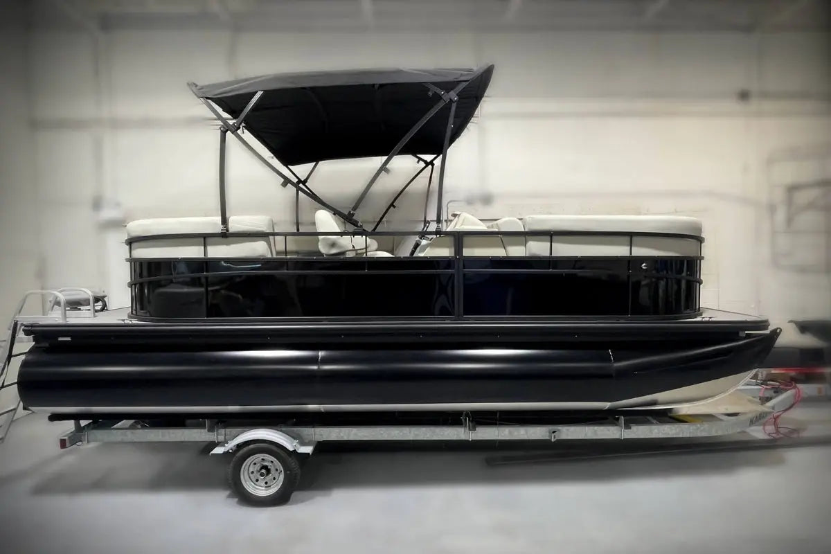 Vision WX Tritoon Electric Boat on a trailer inside a warehouse