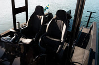 Two black and gray seats on X Shore Pro Electric Boat with water in the background