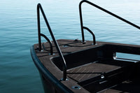 X Shore Pro Electric Boat deck with black railings and wooden floor against a blue water background