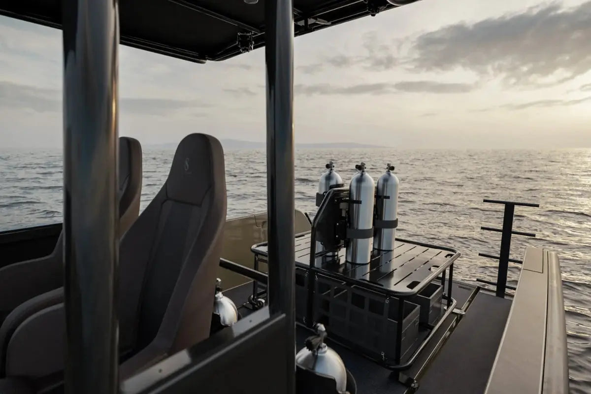 View from inside a vehicle on X Shore Pro Electric Boat with diving equipment on a body of water.