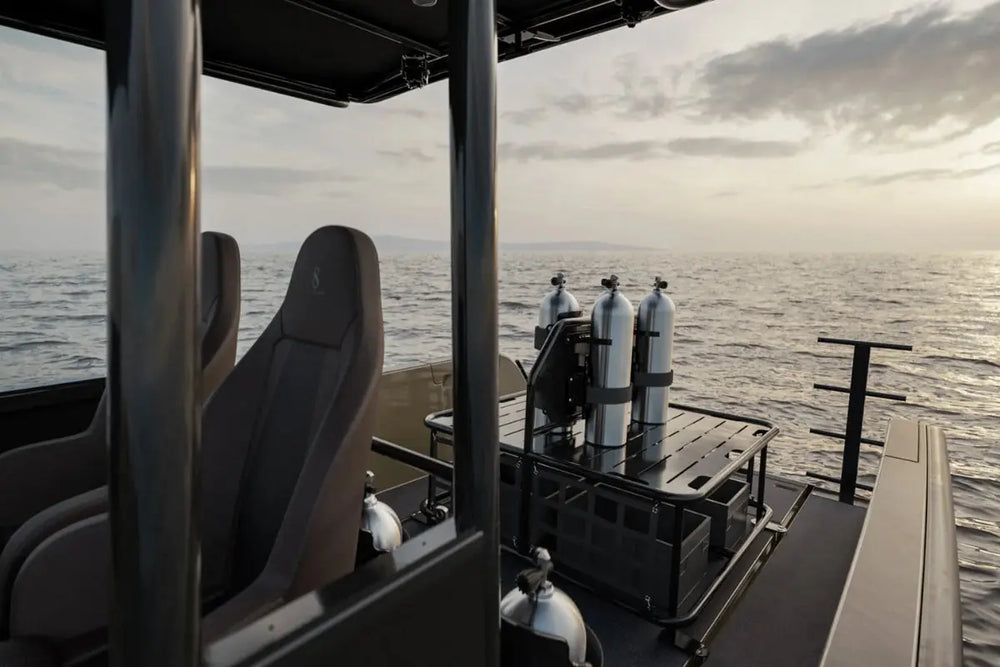 View from inside a vehicle on X Shore Pro Electric Boat with diving equipment on a body of water.
